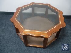 An octagonal glass topped coffee table with under shelf