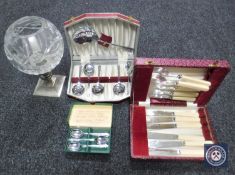 Three boxes of cutlery together with a glass and silver plated candle holder