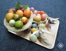 A tray containing a quantity of marble eggs, stone fruit and two bowls,