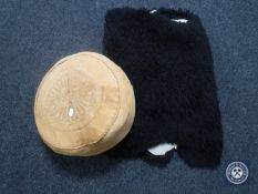 A leather footstool and a sheepskin rug