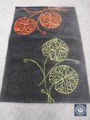 A hand tufted floral black rug, 120 cm x 180 cm, rrp £297.