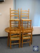 An oval pine extending table and four chairs