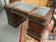 A reproduction mahogany twin pedestal partners desk with green leather top, width 139 cm.