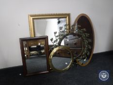 A circular brass porthole mirror and four others