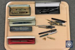 A collection of writing utensils including Parker and Waterman's fountain pens,