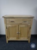 An oak double door cupboard fitted a drawer