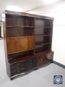 A twin section mahogany serpentine fronted bookcase fitted a cocktail cabinet