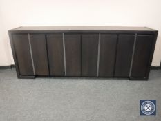 A contemporary black ash low sideboard fitted with four doors, width 243 cm.