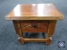 A carved hardwood lamp table fitted a drawer