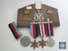 A trio of WWII medals with ribbons together with a Reward of Merit medal with ribbon,