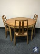 A Nathan teak display unit together with a circular dining table and three chairs