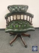 A green buttoned-leather Chesterfield style swivel chair,