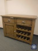 A rustic farmhouse pine kitchen cabinet with wine rack,