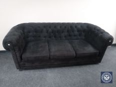 A black button dralon three seater Chesterfield style settee