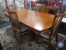 A contemporary extending dining table with leaf and six high backed dining chairs