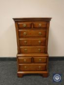 A Reprodux miniature mahogany eight drawer chest on bracket feet,