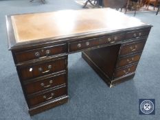 A mahogany twin pedestal knee hole writing desk with inset leather panel