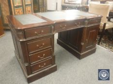 A reproduction mahogany twin pedestal partners desk with green leather top, width 139 cm.