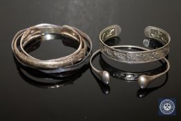 Two sterling silver bangles together with three white metal bangles.
