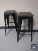 A pair of metal and wood topped breakfast bar stools - black
