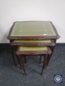 A mahogany leather topped coffee table and nest of tables