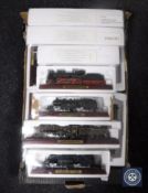 A box containing fifteen scales models of locomotives on wooden stands