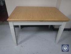 An oak extending dining table on painted base