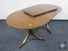 An oval mahogany twin pedestal dining table with leaf