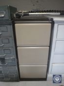 A three drawer metal filing cabinet with key