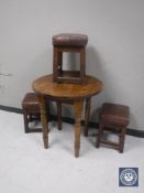 A circular oak pub table and three leather topped stools