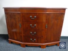An inlaid yew wood shaped front sideboard