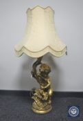 A gilt table lamp in the form of a cherub,