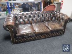 A brown button leather three seater Chesterfield settee