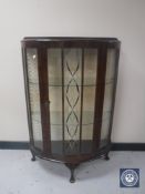 A mid 20th century walnut D-shaped display cabinet