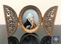 An antique wooden framed painted porcelain plaque depicting a young girl