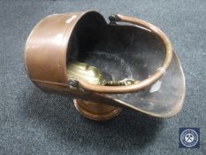 A Victorian copper coal scuttle with a brass shovel