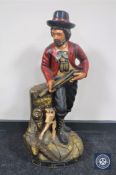 A painted wooden figure of a huntsman with dog