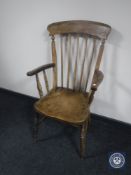 An antique elm kitchen armchair