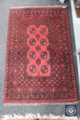 A Turkmen rug, North Afghanistan, the claret field with eight guls enclosed by narrow borders,