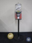 A coin operated sweet dispenser on stand and a bowling ball
