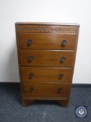 A mid 20th century oak four drawer bachelor's chest