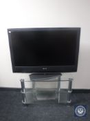 Sony 40" LCD TV with lead and remote on glass stand