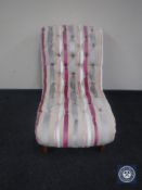 A button back bedroom chair in multi coloured striped fabric.