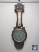 A carved oak cased banjo aneroid barometer with silvered dial