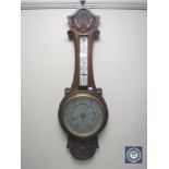 A carved oak cased banjo aneroid barometer with silvered dial