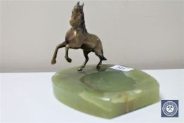 An onyx ashtray surmounted with a gilt metal figure of a horse