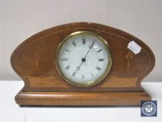 A Victorian inlaid mahogany shaped mantel clock on brass feet