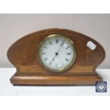 A Victorian inlaid mahogany shaped mantel clock on brass feet