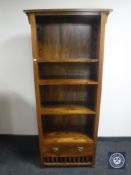 A set of open bookshelves fitted a drawer