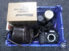 A crate containing two Nikon cameras including an F100 and an Nikkormat with accessories